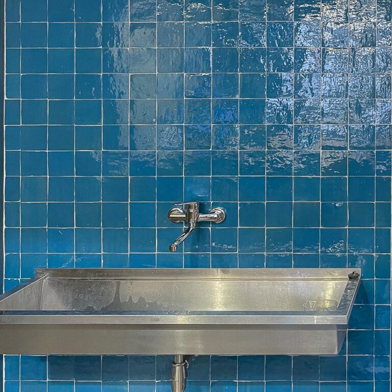 Wastafel met blauwe zelliges als wandtegel