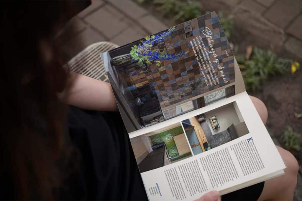 Vrouw leest artikel X-tiles in Landelijk Wonen magazine